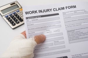 hurted hand holding a work injury claim form, medical and insurance concept